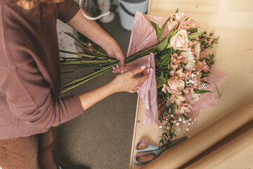 woman's hands making bouquet of flowers