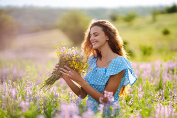 Beautiful woman in the blooming  field. Nature, vacation, relax and lifestyle. Summer landscape.