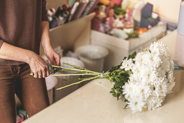 woman's hands making bouquet of flowers