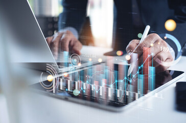 Businessman analyzing financial data, economic growth graph chart on digital tablet. Business...