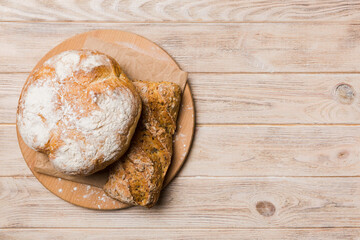 Freshly baked bread on cutting board against white wooden background. top view bread with copy space