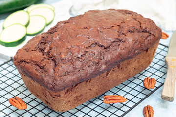 Loaf of homemade chocolate zucchini or courgette bread with pecan nuts, on cooling rack, horizontal