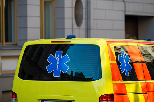 a yellow ambulance emergency car parked on the side of a crowded street, close up, selective focus