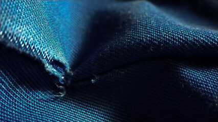 Close-up old work uniform with scuffs on a lowercase seam of blue denim