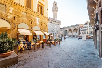 Papier Peint photo Florence Beautiful street with cafe terrace near central square in Florence city, Italy. Vecchio palace with tower on the background. Traveling italian landmarks concept