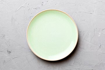 Top view of empty green plate on cement background. Empty space for your design