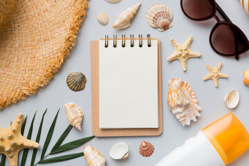 Blank writing book with summer beach accessories on background, copy space. Flat lay with copy space
