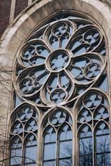 Round window with stained glass on facade of the building. Baroque and Gothic architecture. Church of St. Olga and Elizabeth. Lviv, Ukraine.