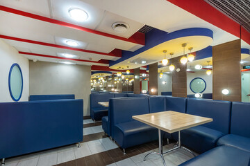 A spacious recreation area of the wellness center with mirrors and blue sofas. A place to relax and have a snack.