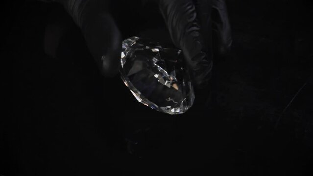 Thief admiring the diamond he gets after successful robbery. Night steal, precious stone for underground jewelry market