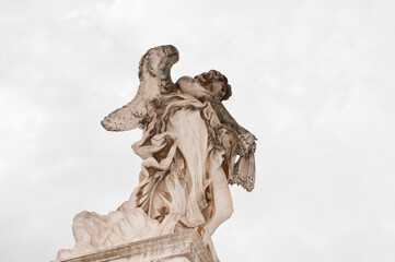 Angel with whips ancient marble statue sculpture historical landmark in Rome, Italy
