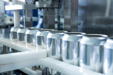 Empty new aluminum cans for drink process in factory line on conveyor belt machine at beverage manufacturing. food and beverage industrial business concept. High quality photo - Powered by Adobe