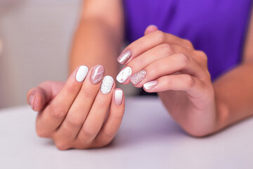 Close up view of beautiful female hands with luxury manicure nails, pink and white gel polish