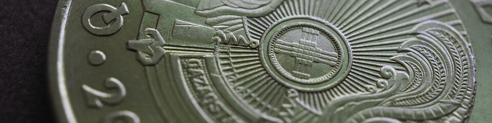 Fragment of Kazakh 50 tenge coin with the country emblem and focus on shanyrak. Close up. Green...
