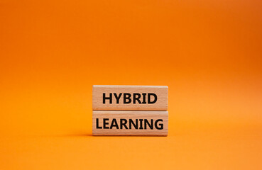 Hybrid learning symbol. Concept word Hybrid learning on wooden blocks. Beautiful orange background....