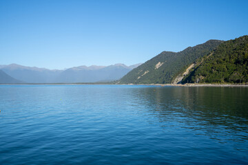 Scenes blue water of Jackson Bay surrounded by Southern Alps mountains