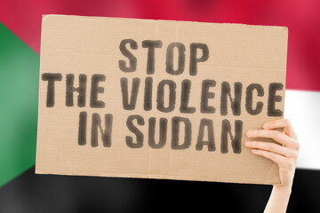 The phrase " Stop the violence in Sudan " is on a banner in men's hands with a blurred Sudani flag in the background. Sad. Rights. Security. Social. Stress. Combat. Hate. Cruelty