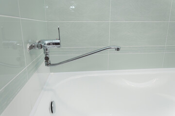 isolated faucet mixer in the bathroom on a light background. aesthetics of plumbing, disconnected water in Russia. the faucet is long, water flows from the faucet