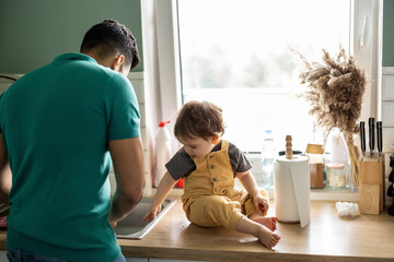 Father with his young child in the home kitchen 
