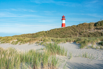 Fototapeta na wymiar Red lighthouse standing near the coast of Sylt, North Sea, Germany 
