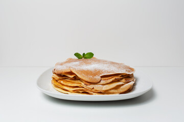 Close-up of plate with vegan thin pancakes, on light grey background.
