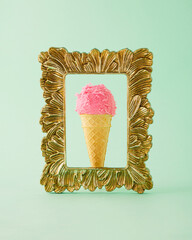 Strawberry ice cream in a retro gold frame on a pastel green background. Minimal summer concept. Still life.