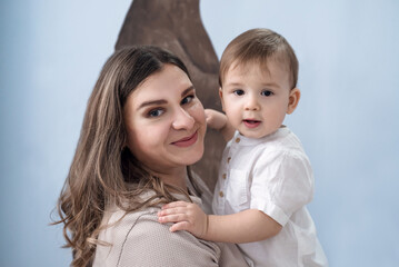 Young mother with her one years old little son posing in children room. Selective focus. Casual lifestyle photo.