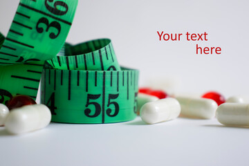 Measuring tape, pills on a light background