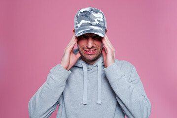 Furious and frustrated young man having a headache, portrait of a handsome caucasian man