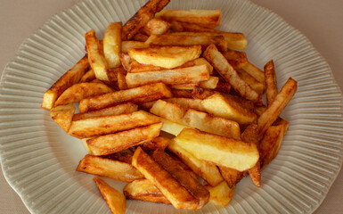 Homemade french fries or potato chips in the plate.