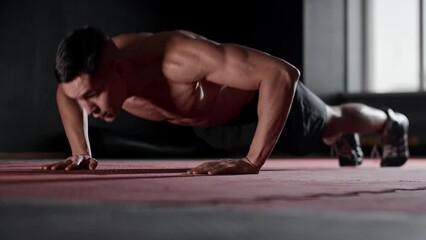 Fit young man does push ups and clapping his hands