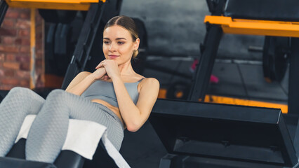 ABS exercise. Fit caucasian fashionable gym girl doing sit ups to train her core muscles. High quality photo