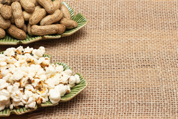 brazilian june party snacks like popcorn, peanuts and corn on straw background