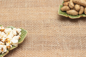 brazilian june party snacks like popcorn, peanuts and corn on straw background