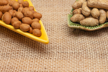 brazilian june party snacks like popcorn, peanuts and corn on straw background