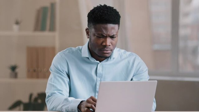 Angry guy annoyed african american man male boss worker dissatisfied has problem with computer system work feels wrath aggression with unsuccessful business deal slow internet read bad news data loss