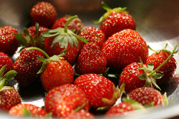 Fresh strawberries on the white plate on wooden table. Fresh nice strawberries. Heap of Red strewberry on plate close up. Juice strawberry. Strawberry on fruit farm.