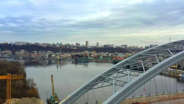 4k aerial footage flight past an unfinished bridge overlooking the Dnieper River and the right bank of Kyiv. Views of the hilly Kyiv eclecticism modern and ancient architecture.Traffic. Ukraine 