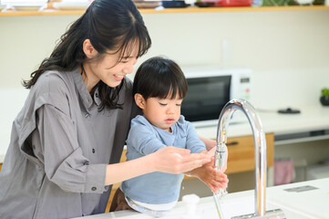 Toddler washing hands with mom Copy space