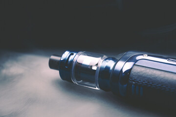 Vape on a black background in smoke, an electronic cigarette for smoking nicotine, a lot of steam...