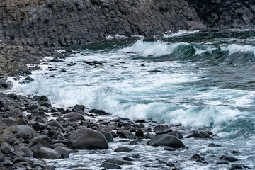 Waves comes rocky beach in cloudy day, Japan.