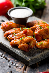 Buffalo chicken wings with green onion on the board extreme macro close up vertical