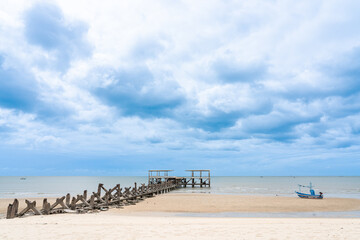 Old port for fishing boats, dilapidated and small fishing boats on the sandy beach sea, rain cloudy sky in the background, Pranburi,Prachuap Khiri Khan Thailand