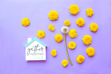 Obraz premium Yellow dandelion flowers and white fluffy dandelion figure of a house on a lilac background. Color of the year 2022. 