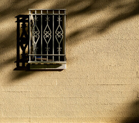 Window and Bars on a Golden Building Wall.