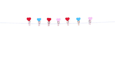 Colorful seven wood clothes pins in heart shape patterns hanging on white string isolated on white...