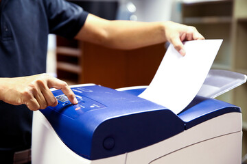 Technician hand press button and load paper in tray to using photocopier for scanning fax or...