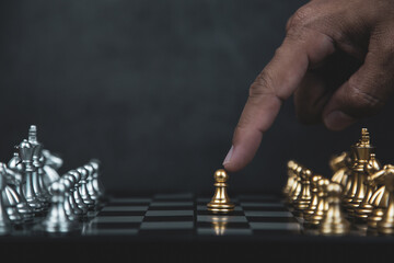 Hand choose chess stand front of the line on chessboard concept of challenge or team player or business team and leadership strategy or strategic planning and human resources and risk management.