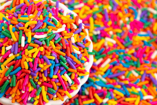 A Bowl of Rainbow Sprinkles on a Table of Sprinkles