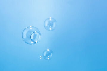 Abstract Transparent Soap Bubbles Floating on Blue Background. Soap Sud Bubbles Water